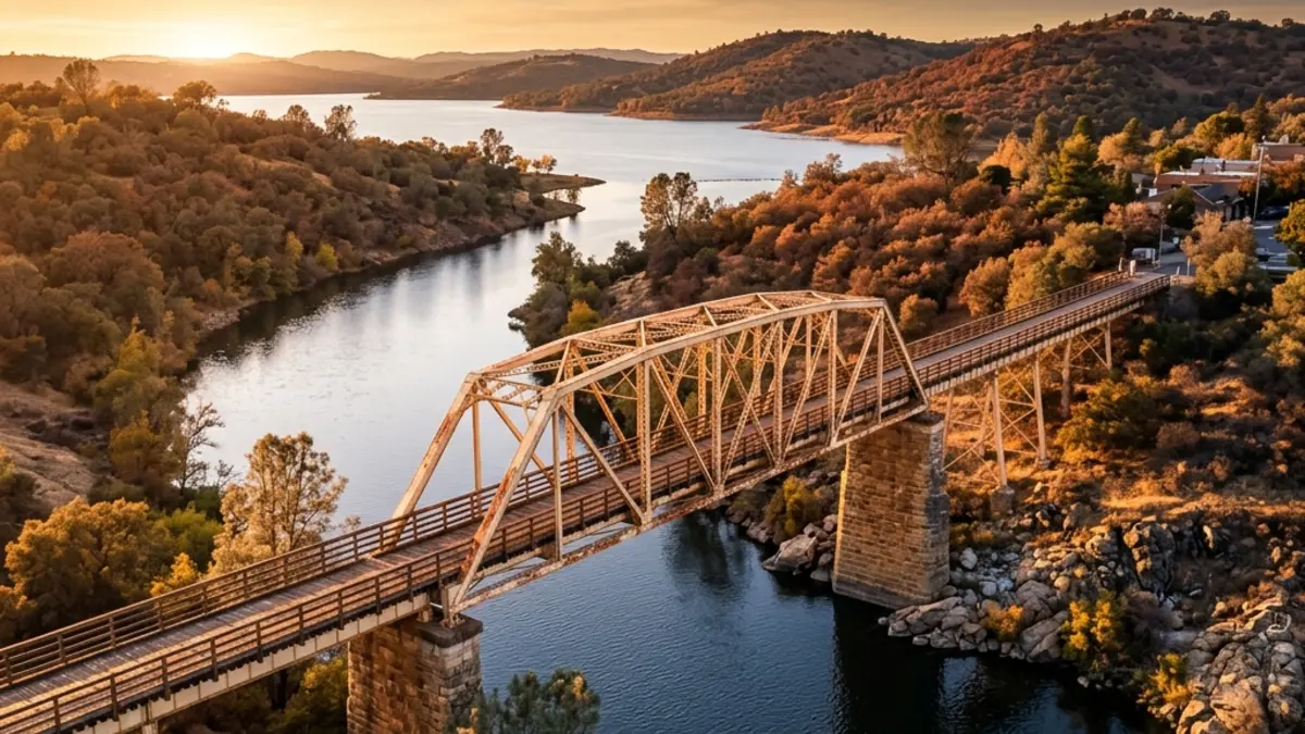 Historic Folsom truss bridge crossing the American River with the sunset reflecting on the water.